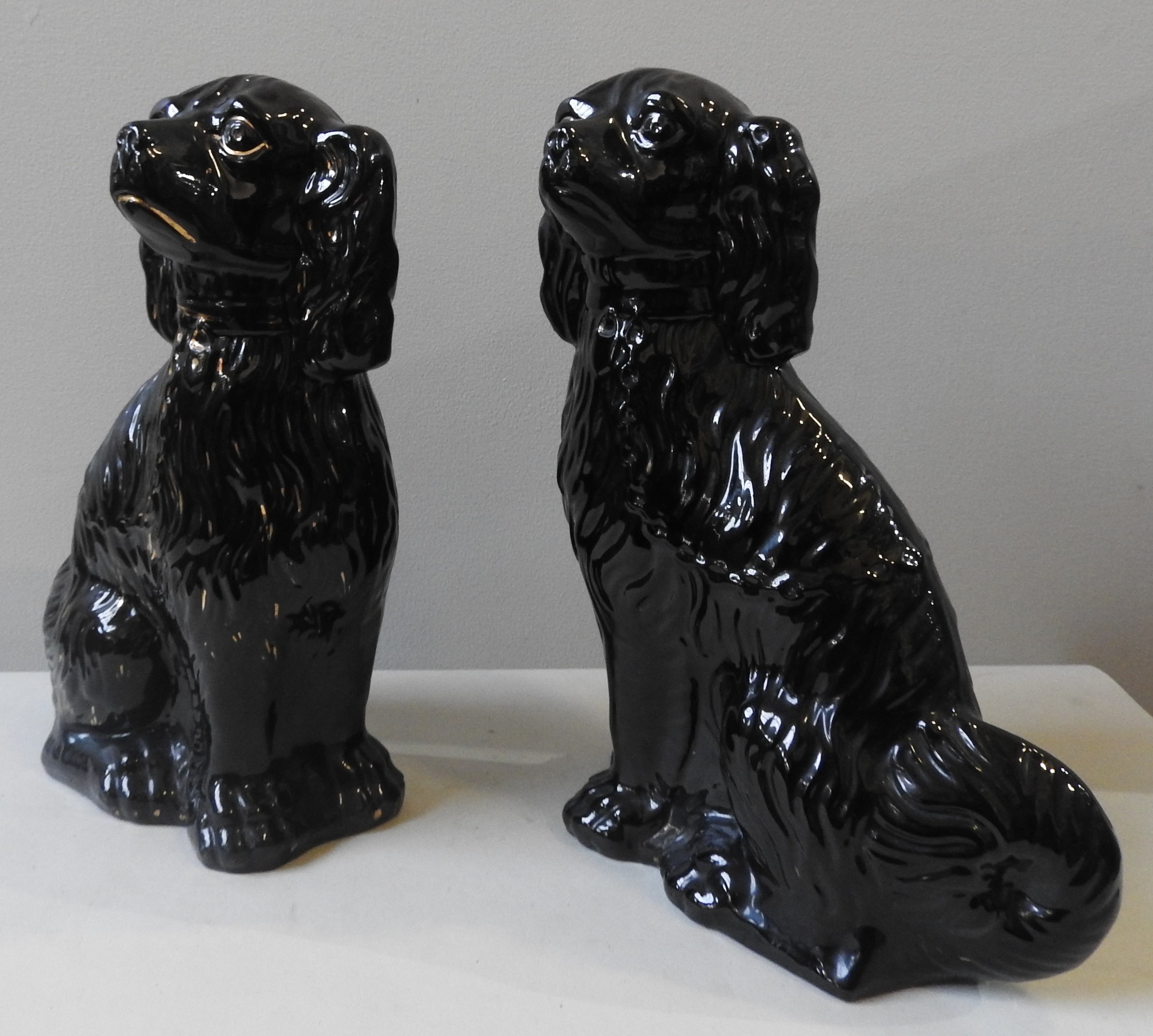 TWO BLACK GLAZED STAFFORDSHIRE SPANIEL FIGURES, 20TH CENTURY, in the Victorian style, with gilded - Image 2 of 3