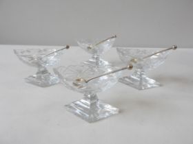 A SET OF FOUR GEORGIAN CUT GLASS BOAT-SHAPED PEDESTAL SALTS on diamond shaped feet with four