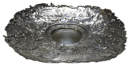 A LATE VICTORIAN SILVER INKWELL STAND, oval form with profuse repousse decoration throughout, the