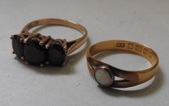 A 22CT GOLD OPAL SET RING AND A 9CT GOLD GARNET SET RING, the 22ct gold ring set with a single