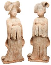 A RARE AND EXCEPTIONALLY LARGE PAIR OF POTTERY COURT LADIES HOLDING DOGS TANG DYNASTY (618-907) each