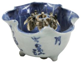 A CHINESE PORCELAIN BLUE AND WHITE PUZZLE CUP CHONGZHEN, CIRCA 1640 of lotus-leaf form on three