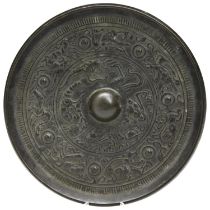 A BRONZE MIRROR TANG DYNASTY (618-907) decorated in relief with dragons and mythical beasts 15cm