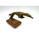 GREYHOUND DOG CAR MASCOT A brass car mascot in the form of an greyhound, mounted on a wooden base.