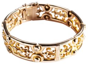 A VICTORIAN GOLD BANGLE, CIRCA 1860 of pierced scroll design with bead work detail. Integral
