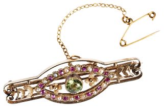 A PERIDOT, GOLD AND RUBY BROOCH, CIRCA 1890 the circular mixed-cut peridot millegrain collet set