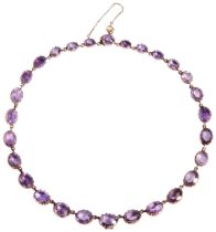 A LATE VICTORIAN AMETHYST AND GOLD RIVIERE, CIRCA 1890 the graduating row of twenty eight oval