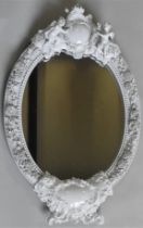 A 19TH CENTURY MEISSEN BLANC DE CHINE OVAL WALL MIRROR, the porcelain frame with a central crown