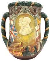 A ROYAL DOULTON GEORGE V SILVER JUBILEE LOVING CUP, signed by Charles Noke, no. 751/1000 26 cm high