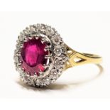 18ct gold, red stone and diamond cluster ring, the central oval cut red stone weighing approximately