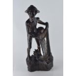 Hardwood carved figure of a fisherman pulling his nets and catch from the water H50.5cm