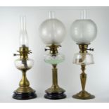 Three brass oil lamps with glass reservoirs, shades & flus, including Hinks & Lamp Works