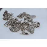 Silver bracelet suspending numerous silver & white metal charms, gross weight 80.7 grams