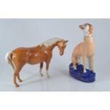 A Staffordshire seated greyhound, circa 1860, 20.5cm height, together with a Beswick Palomino horse,