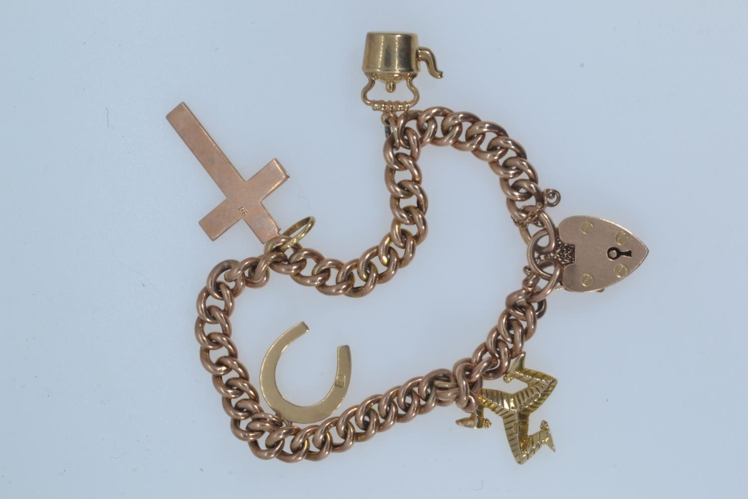 9ct rose gold bracelet with a heart-shaped padlock clasp, suspending four charms, including three 9c