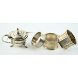 Victorian silver glass lined mustard pot with spoon and three silver napkin rings, various maker's