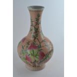 A Chinese vase, bottle shaped with flared neck and decorated with nine peaches on an extensive peach