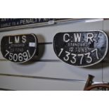 Two cast iron D-shaped train wagon plates, including 'LMS standard 20 tons 750691' and 'G.W.Ry. stan