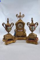 Gilt metal and hand painted porcelain three piece mantle clock garniture, late C19th/early C20th,