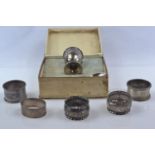 Five silver napkin rings and a boxed silver egg cup with spoon set, various maker's and dates, inclu