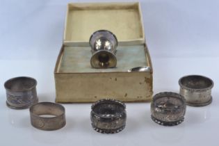 Five silver napkin rings and a boxed silver egg cup with spoon set, various maker's and dates, inclu