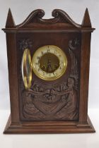 A late C19th oak mantle clock carved with two seated angels, housing a French Japy Freres movement w