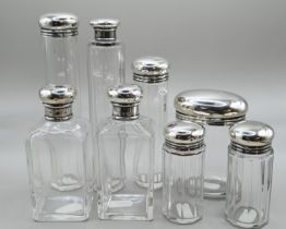 Set of six silver lidded vanity bottles, maker's mark rubbed, London 1911, together with a similar b