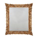 A GILTWOOD AND COMPOSITION WALL MIRROR IN GEORGE III STYLE