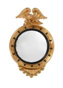 A GEORGE IV GILTWOOD AND PARCEL EBONISED CONVEX MIRROR