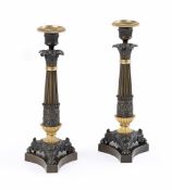 A PAIR OF FRENCH PATINATED AND PARCEL GILT CANDLESTICKS