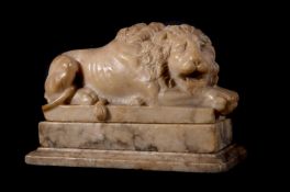 A 'GRAND TOUR' CARVED VARIEGATED ALABASTER MODEL OF A RECUMBENT LION ITALIAN