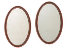 A PAIR OF PAINTED OVAL WALL MIRRORS