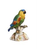 A MEISSEN (PROBABLY OUTSIDE DECORATED) MODEL OF A GREEN PARROT PERCHED ON A STUMP