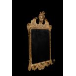 A GEORGE II CARVED GILTWOOD WALL MIRROR, CIRCA 1735