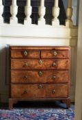 A GEORGE I FIGURED WALNUT AND FEATHER BANDED BACHELOR'S CHEST OF DRAWERS, CIRCA 1720