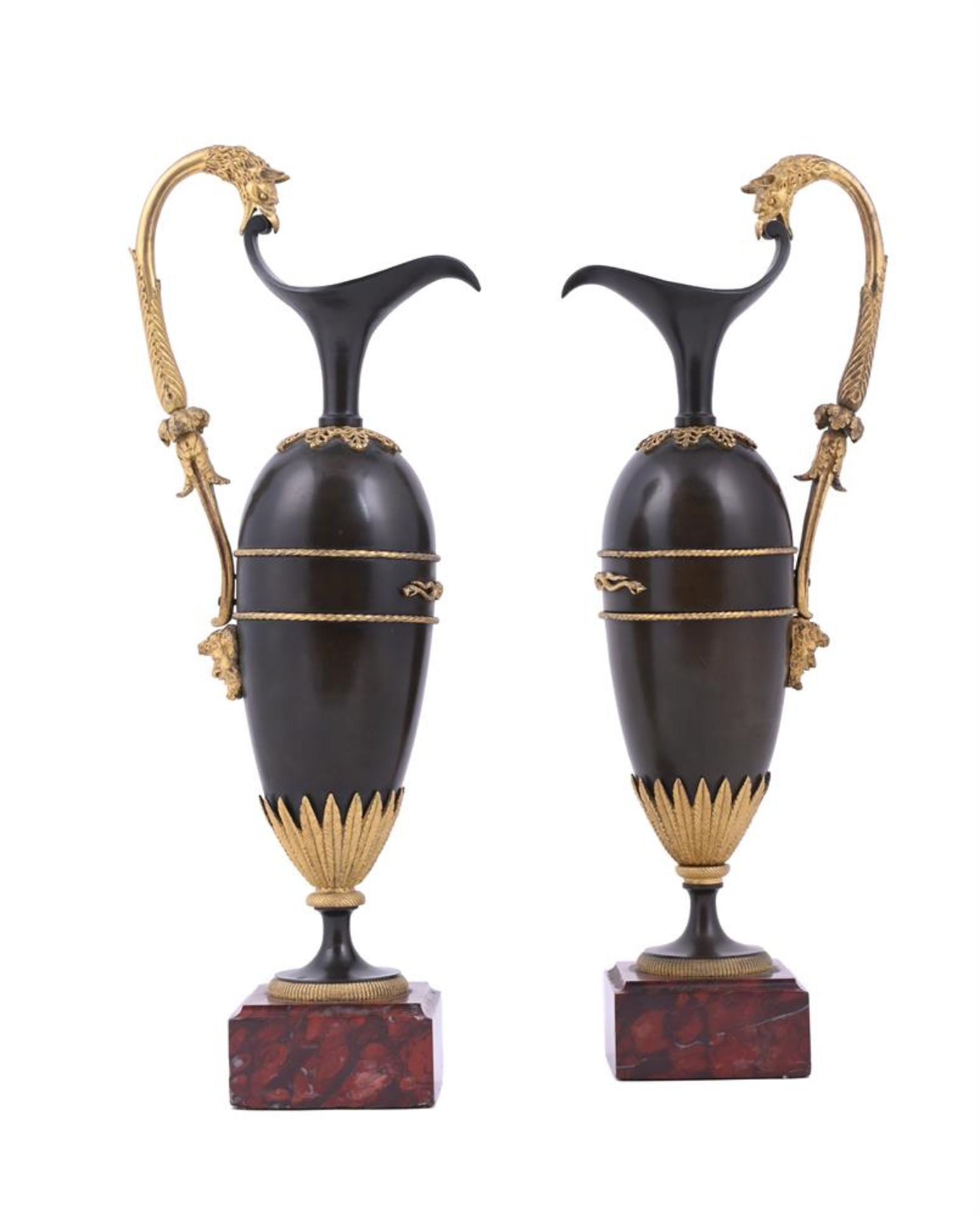 A PAIR OF PATINATED METAL AND PARCEL GILT EWERS IN NEOCLASSICAL TASTE
