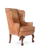 A WALNUT AND LEATHER WING ARMCHAIRIN 18TH CENTURY STYLE