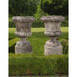 ‡ A PAIR OF CARVED LIMESTONE GARDEN URNS IN 18TH CENTURY STYLE