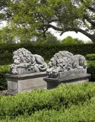 Ω A PAIR OF SCULPTED LIMESTONE MODELS OF RECUMBENT LIONS