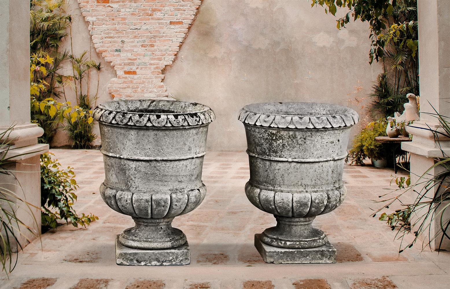 ‡ A PAIR OF CARVED LIMESTONE PLANTERS