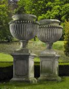 Ω A PAIR OF LARGE AND IMPRESSIVE CARVED LIMESTONE GARDEN URNS ON PLINTHS IN IMPERIO TASTE