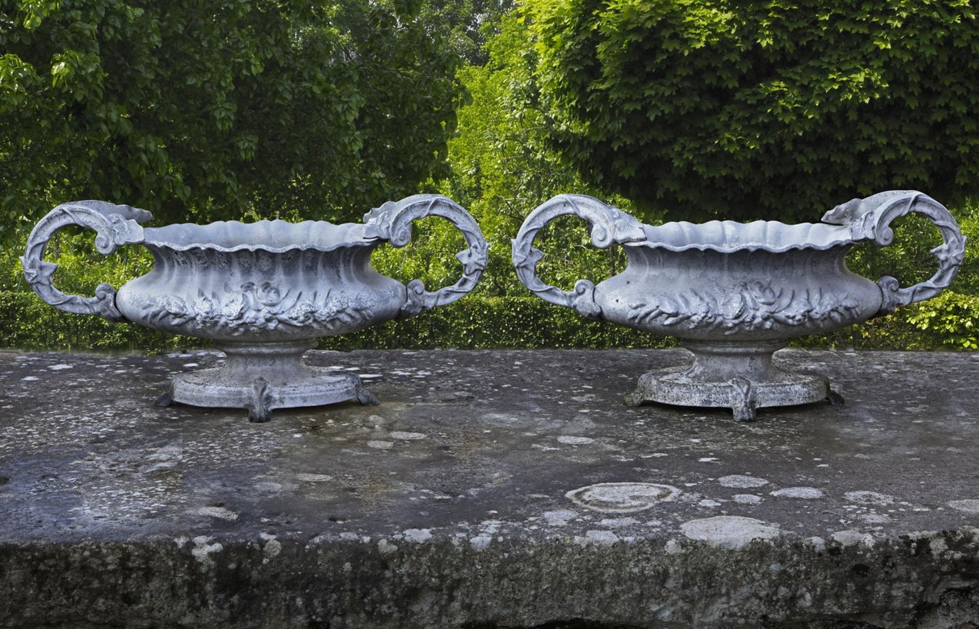 ‡ A PAIR OF ENAMELLED CAST IRON OVAL TWIN HANDLED PLANTERS