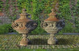 ‡ A PAIR OF ORNATE CAST IRON GARDEN URNS AND COVERS