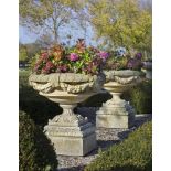 Ω A PAIR OF CARVED LIMESTONE GARDEN URNS