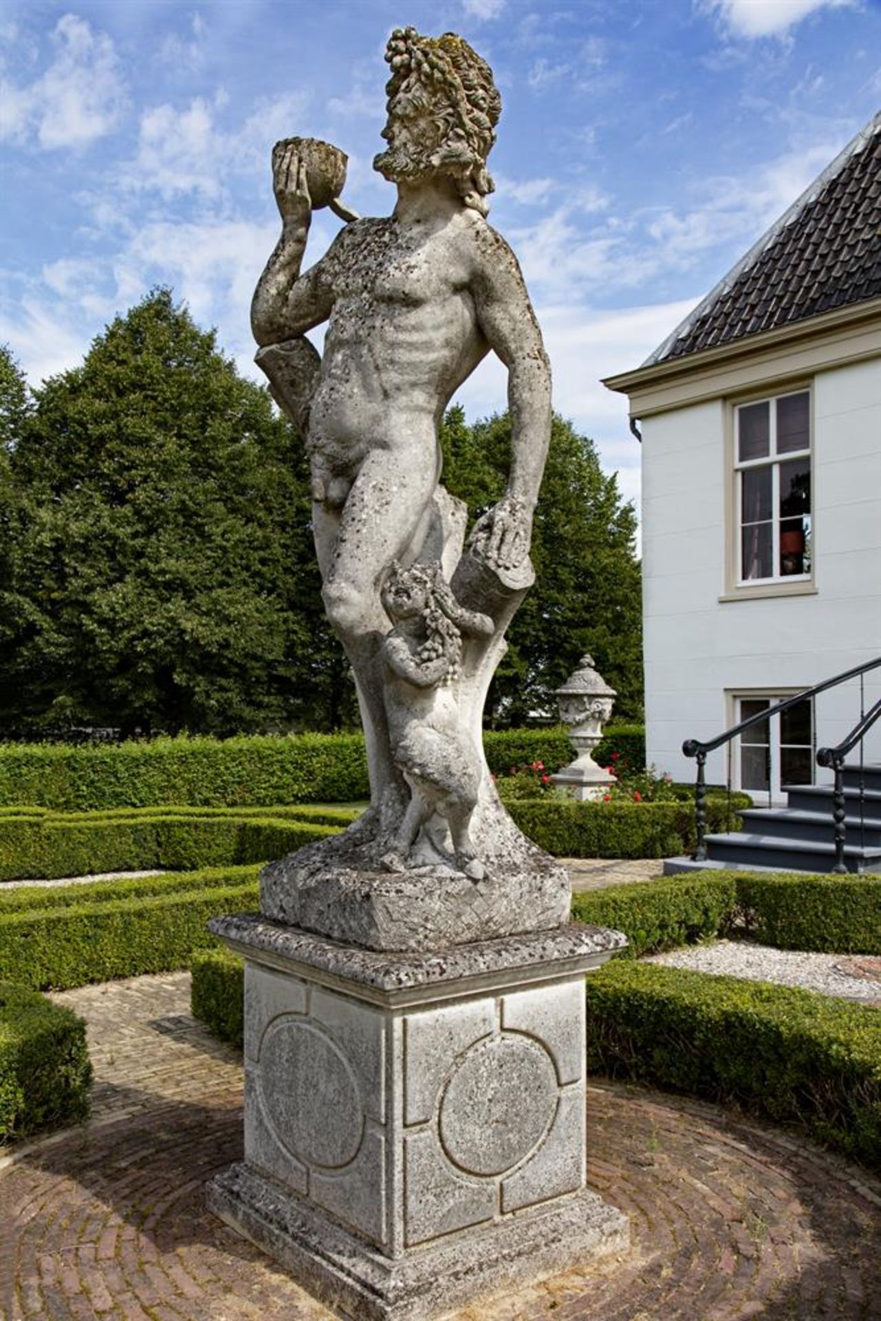 ‡ A MONUMENTAL AND IMPRESSIVE ITALIAN SCULPTED LIMESTONE GROUP OF BACCHUS WITH A SATYR