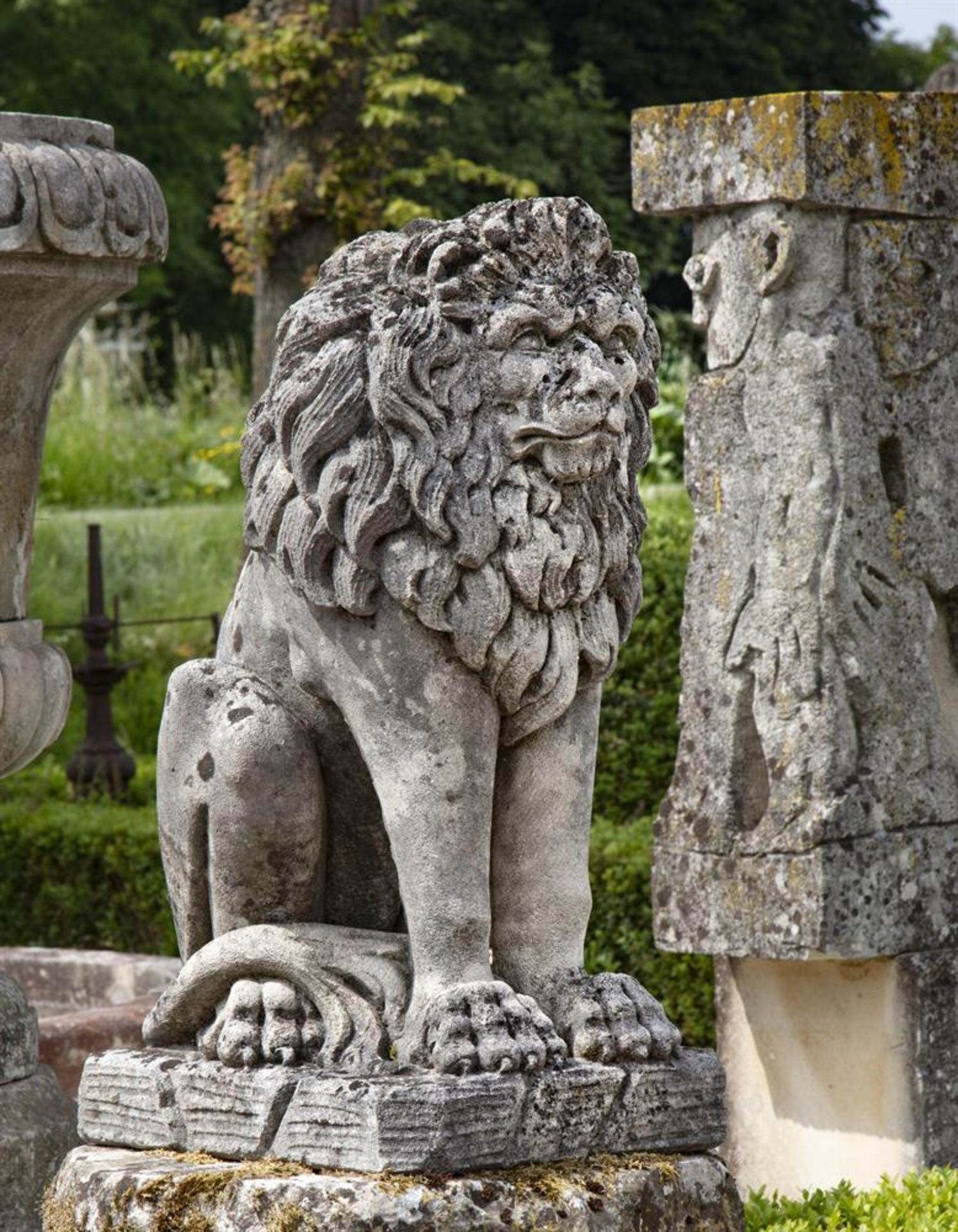 ‡ A SCULPTED LIMESTONE MODEL OF A SEATED LION