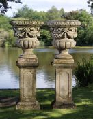 ‡ A PAIR OF CARVED LIMESTONE GARDEN URNS