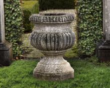 ‡ A CONTINENTAL CARVED STONE GARDEN URN