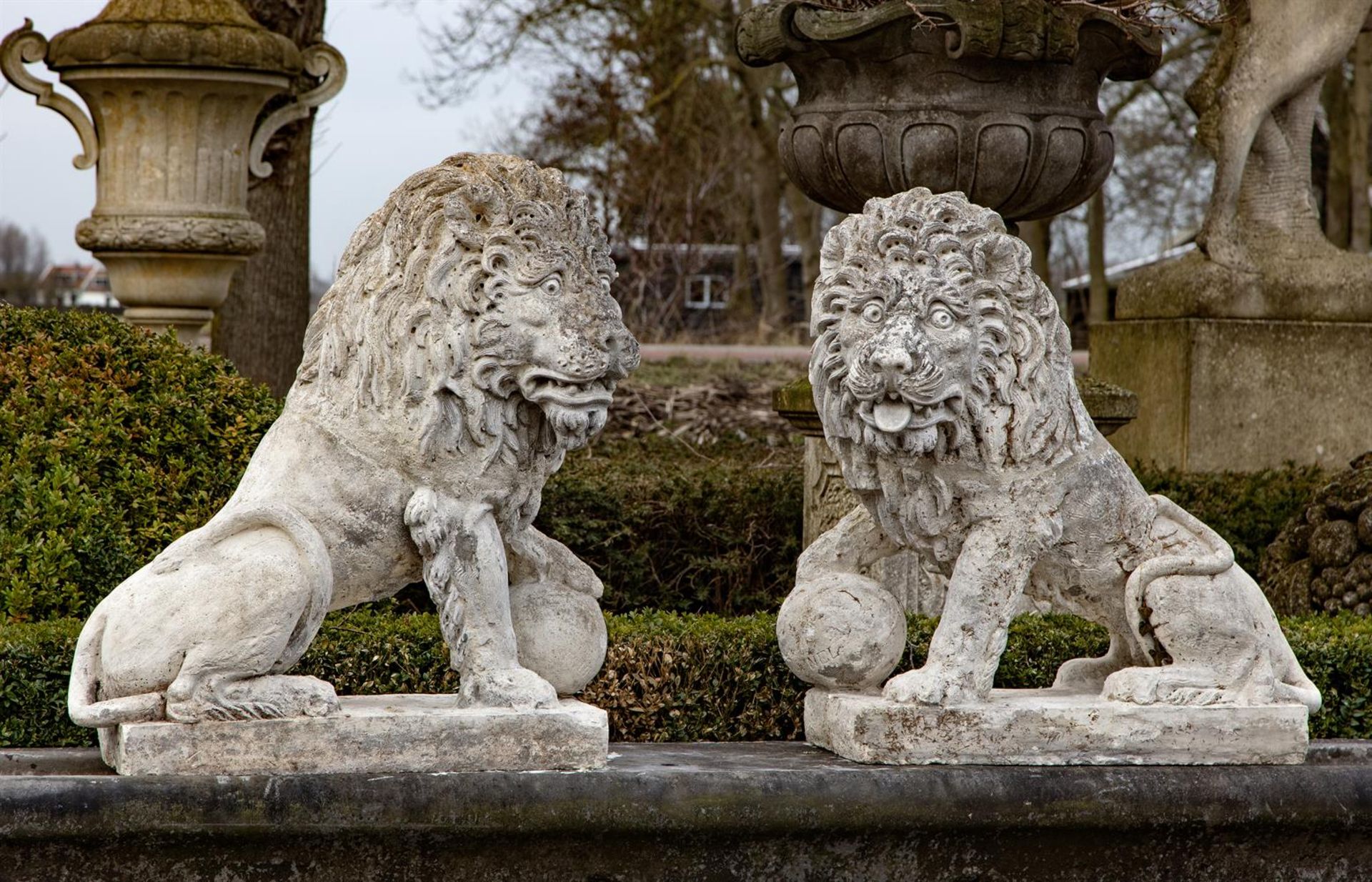 ‡ A PAIR OF COMPOSITION STONE MODELS OF LIONS IN THE 17TH CENTURY STYLE