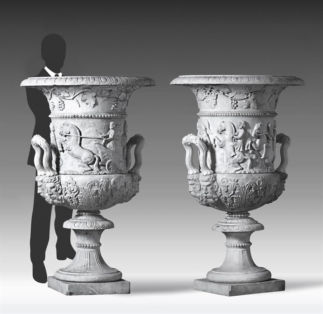 ‡ A PAIR OF MONUMENTAL ITALIAN SCULPTED WHITE MARBLE URNS IN THE MANNER OF THE MEDICI VASE